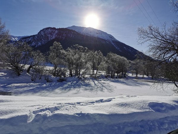 Winter Engadin zugefrorener See vor Berg